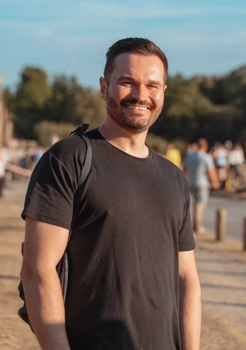 Sam Buckingham smiling outdoors in warm evening light