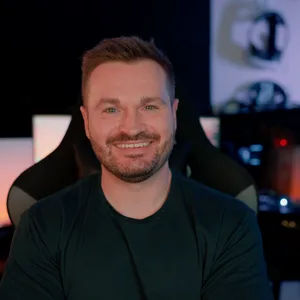 Professional portrait of Sam Buckingham seated in a technology studio